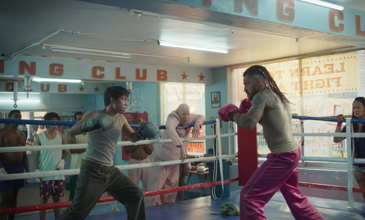 Liborio pelea en un gimnasio de boxeo de barrio mientras un grupo lo mira desde las cuerdas