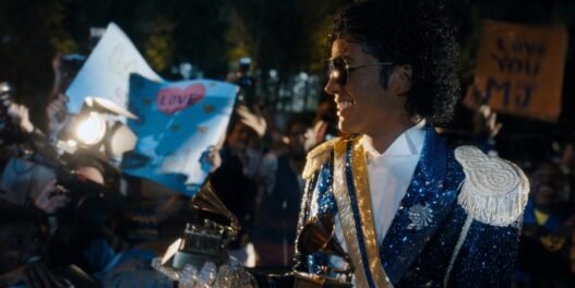 Jaafar Jackson como Michael Jackson sonriendo entre fans con un gramófono de los Grammy