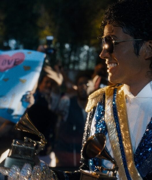Jaafar Jackson como Michael Jackson sonriendo entre fans con un gramófono de los Grammy