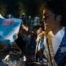 Jaafar Jackson como Michael Jackson sonriendo entre fans con un gramófono de los Grammy