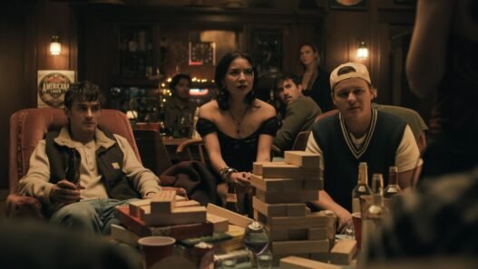Personajes de Obsession sentados alrededor de una mesa con una torre de bloques de madera