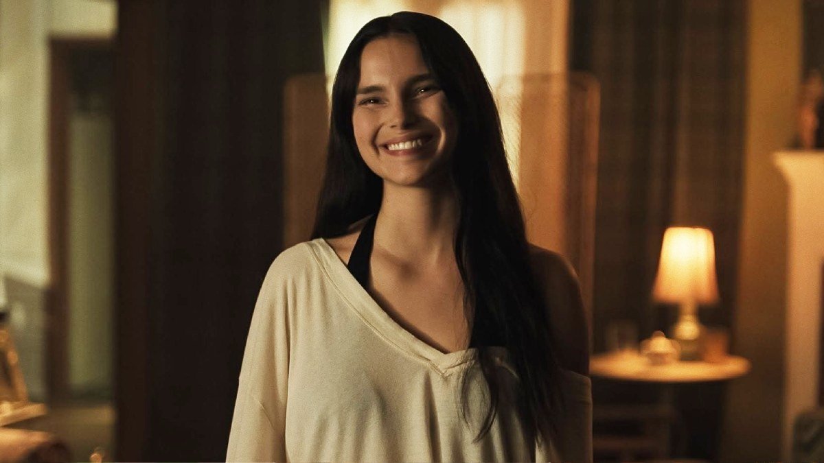 Una mujer sonriendo en una sala con luz cálida en Obsession