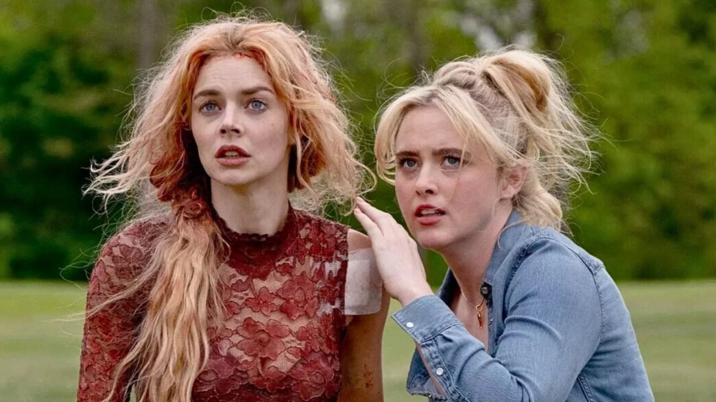 Samara Weaving y Kathryn Newton con ropa manchada de sangre en un jardín
