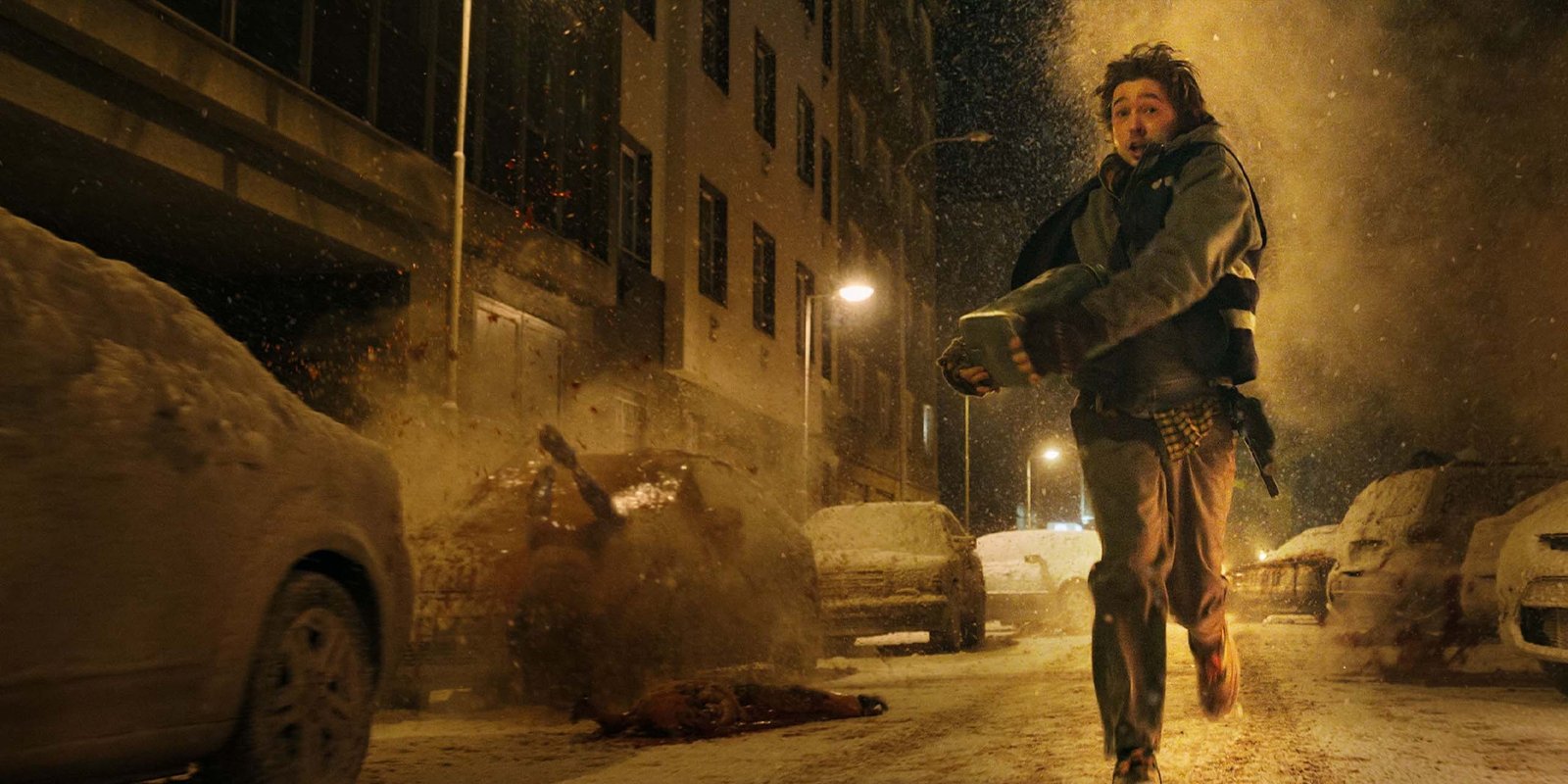 Un hombre corriendo por una calle nevada de noche en Resident Evil