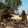 Dylan O'Brien y Rachel McAdams sentados en una playa en Send Help