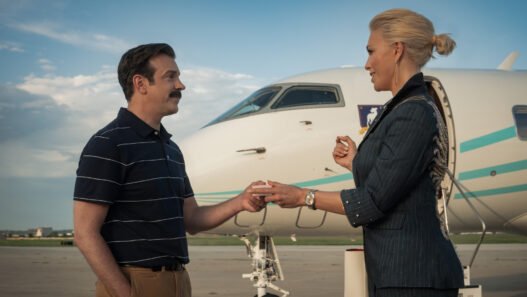Jason Sudeikis como Ted Lasso estrechando la mano de Rebecca frente a un avión privado