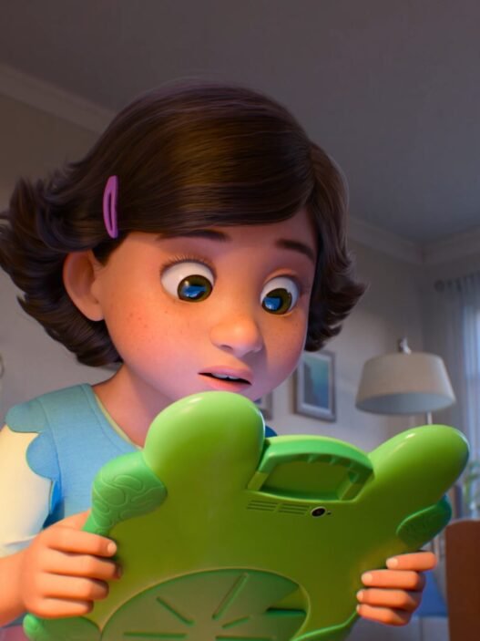 Bonnie sorprendida sosteniendo Lilypad, una tableta verde con forma de rana, en Toy Story 5