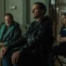 Stephen Root, Matthew Rhys y Kate O'Flynn sentados en un pasillo en Widow's Bay